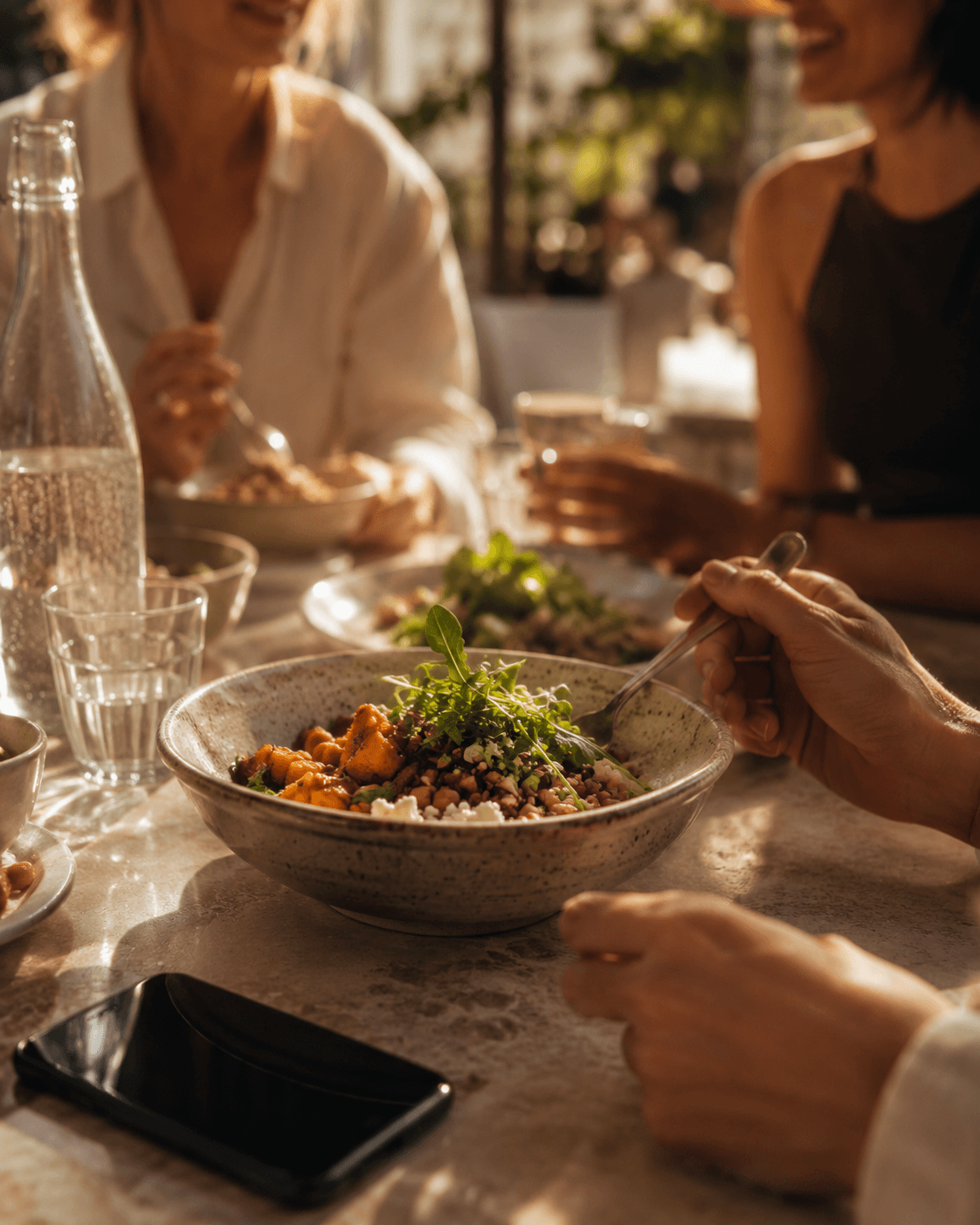 Lunch out — a bowl on a restaurant table, hands and phone in frame (real)